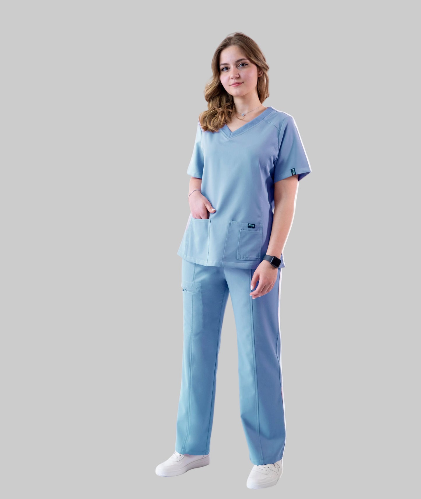 Woman wearing a light blue scrub set on a white background