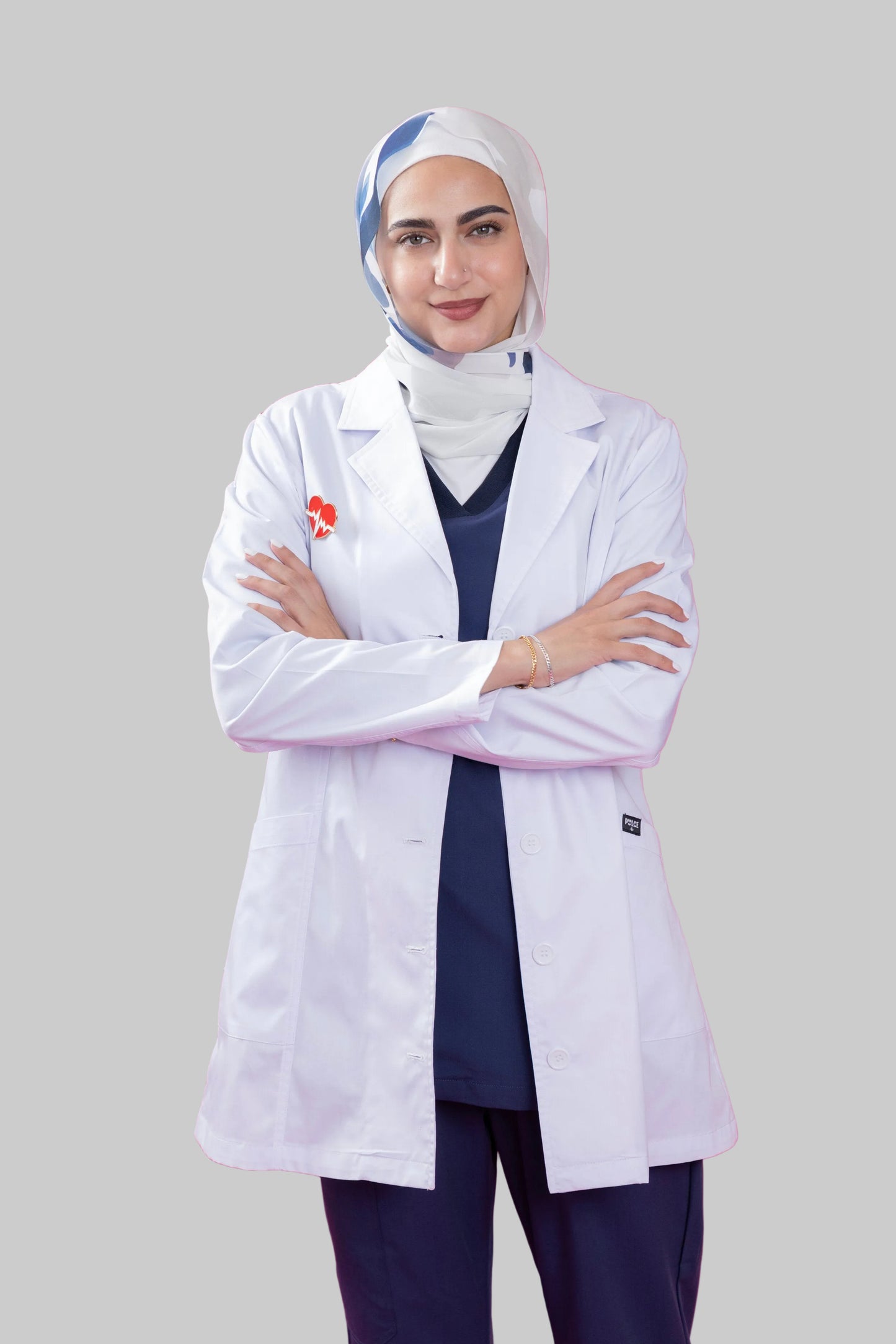 Person wearing a white lab coat with a pink background