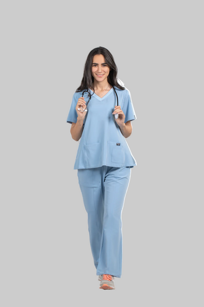 Woman wearing a light blue scrub set with 'Pulse' branding in the background