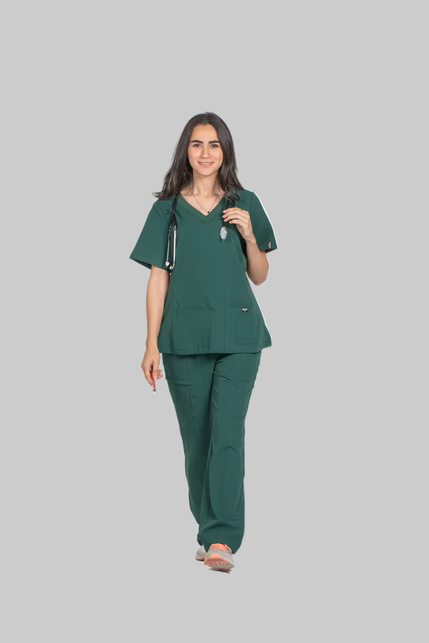 Woman wearing a green scrub set with 'Pulse' branding on a white background